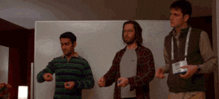 Three men moving their hands in sync