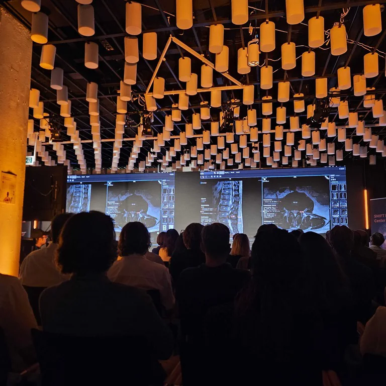 an auditorium of about a hundred watching the same slices on three stage screens