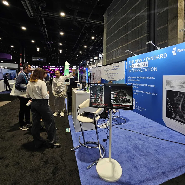 a stand on the exhibition floor with the sagittal and axial series running on two monitors